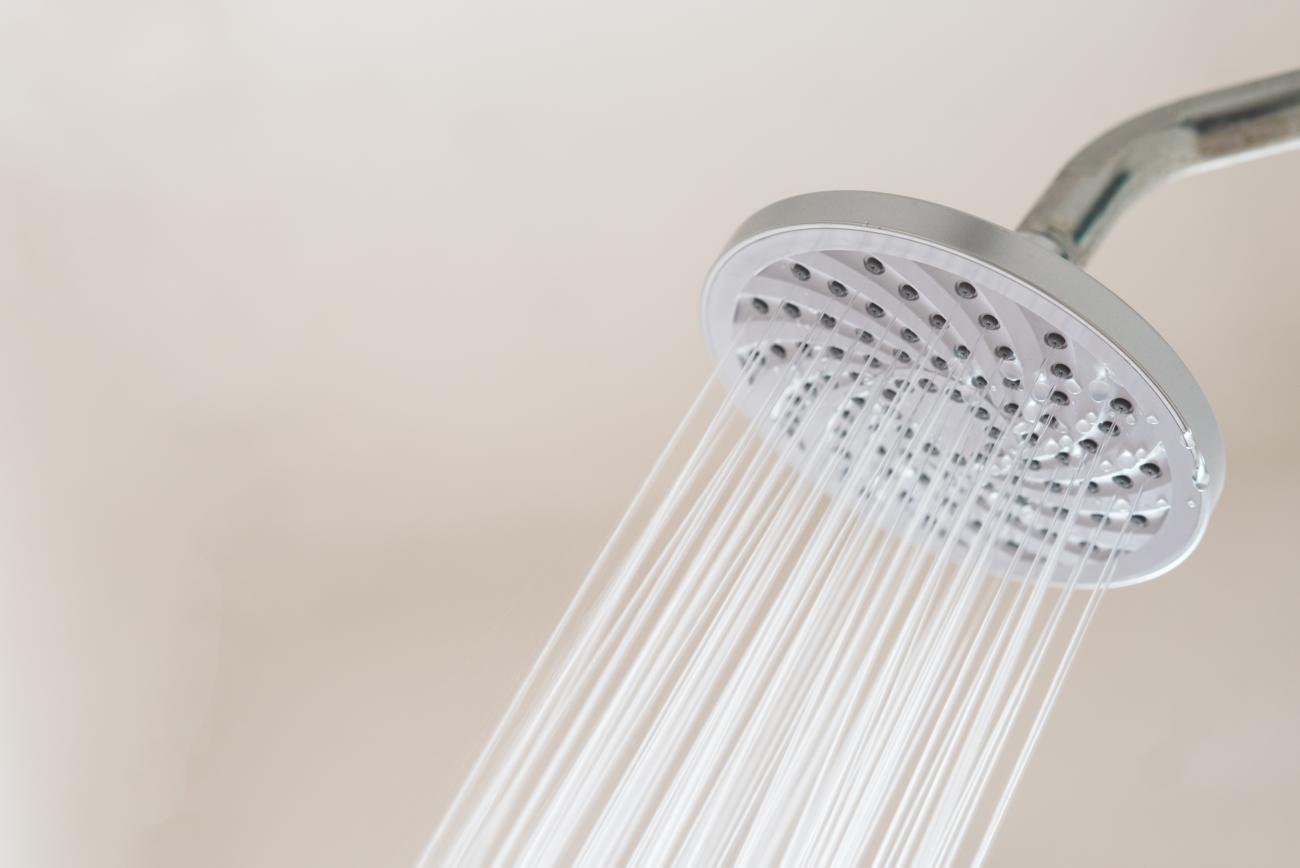 Close up of a showerhead with water coming out