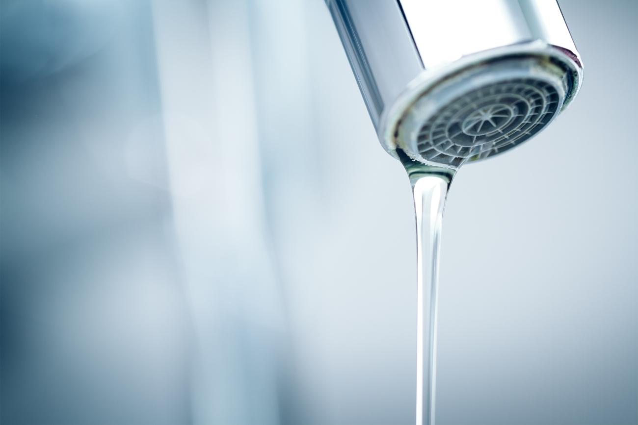 Close up of a small stream of water coming from a faucet