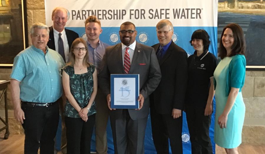 A group of Cleveland Water employees pose together with an award