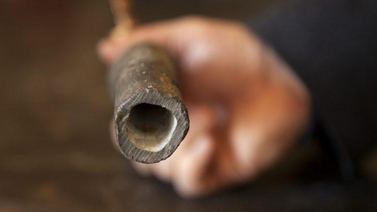 A close up of the interior of a water pipe showing the thin white coating created by orthophosphate