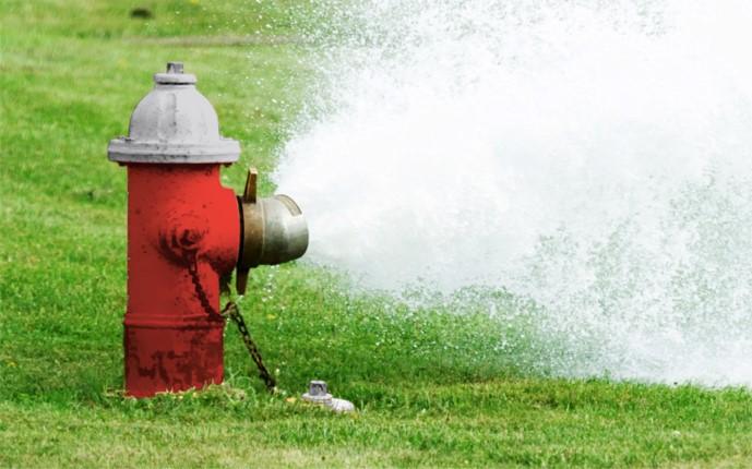 A red fire hydrant with water gushing from it